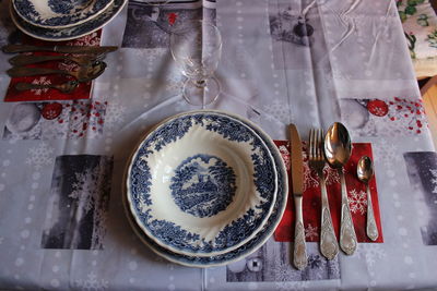 High angle view of crockery by kitchen utensils on table