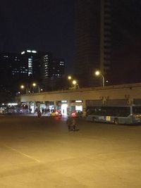 Man in illuminated city against sky at night