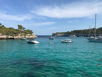 Sailboats moored on sea against sky