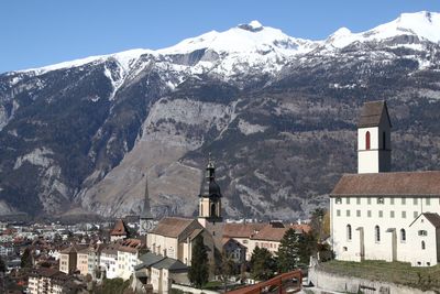 Buildings against mountain in town during winter