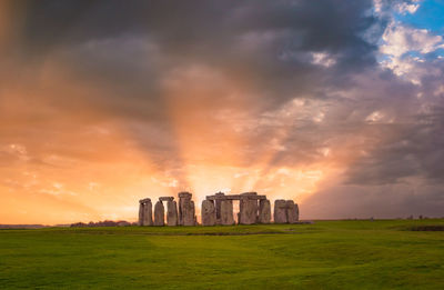 Amazing sunset at stonehenge in england with dramatic sky and sun rays