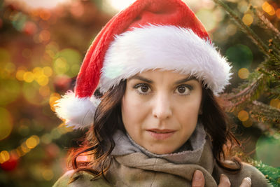 Close-up portrait of young man with hat on tree