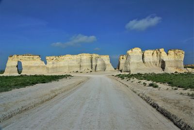 Road passing through landscape against blue sky