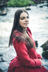 Portrait of smiling young woman standing in river