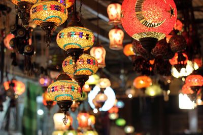 Illuminated lanterns hanging at market stall