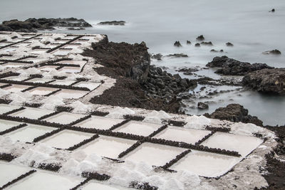 High angle view of rocks on beach against sky