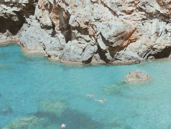 Tourists swimming close to rock formations