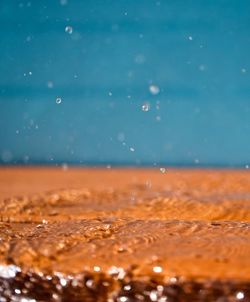 Close-up of splashing water on orange wood