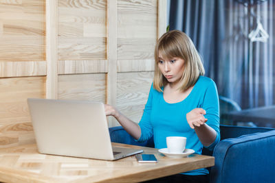 Young woman using laptop at table
