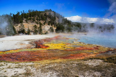 Steam emitting from hot springs against sky