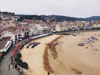 High angle view of people on beach against buildings in city