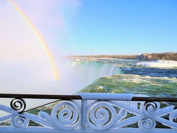 Scenic view of rainbow over sea against clear sky