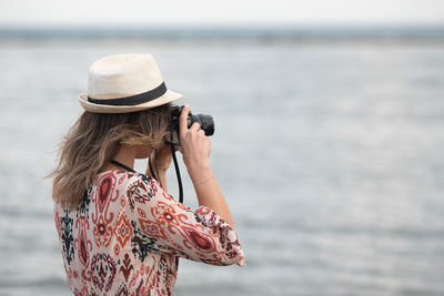 Rear view of woman photographing sea