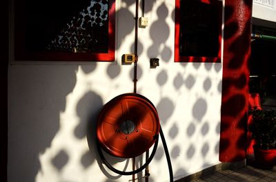 Close-up of electric lamp on table against wall