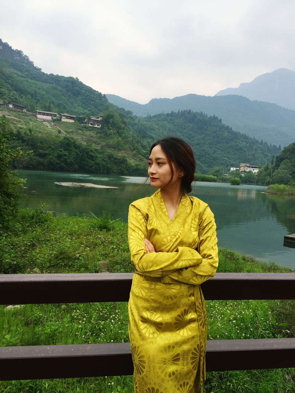 BEAUTIFUL WOMAN STANDING BY LAKE AGAINST MOUNTAINS