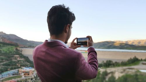 Man photographing mountain through smart phone