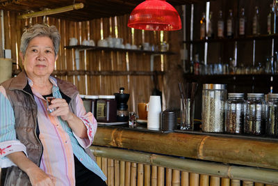 Portrait of senior woman holding drink