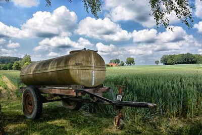 Horse cart on field against sky