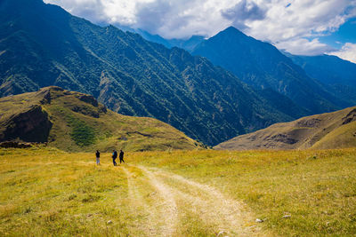 Men walk along the road high in the mountains, the village of galiat, north ossetia