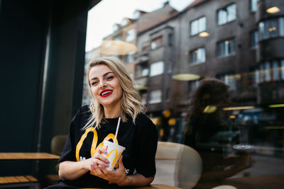 Portrait of a smiling young woman holding ice cream