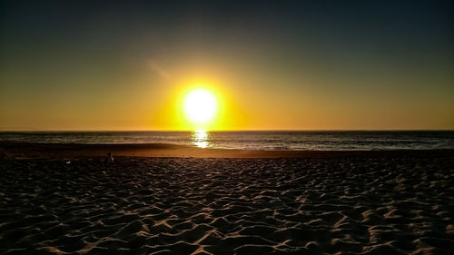 Scenic view of sea against clear sky at sunset