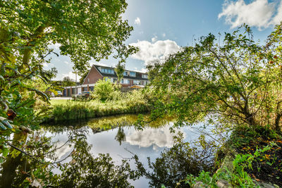 Buildings by lake against sky