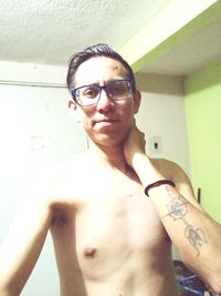 Portrait of young man standing against wall