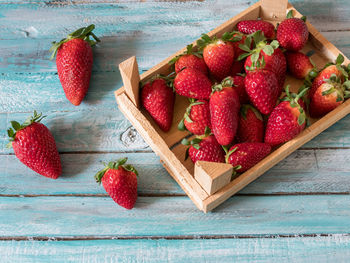 High angle view of strawberries and box on wooden table