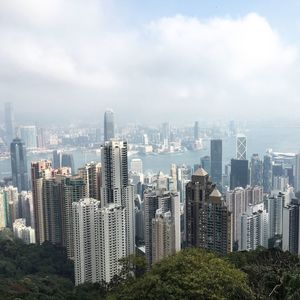 Skyscrapers in city against cloudy sky