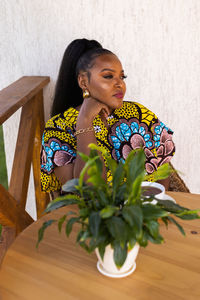 Side view of young woman sitting on table