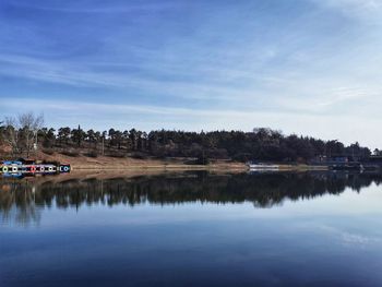 Scenic view of lake by trees against sky