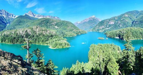 Scenic view of lake and mountains against blue sky