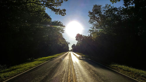 Road amidst trees against sky