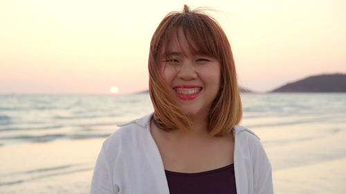 Portrait of teenage girl at beach during sunset