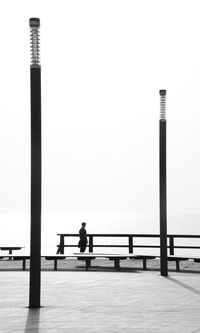 Silhouette people looking at sea against clear sky