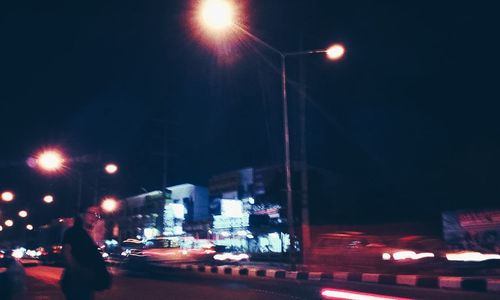 Cars on illuminated street at night