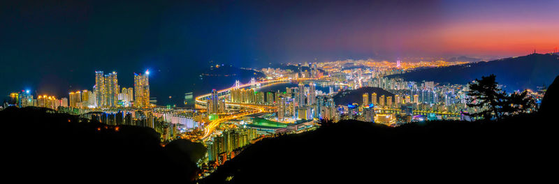 Illuminated buildings against sky at night