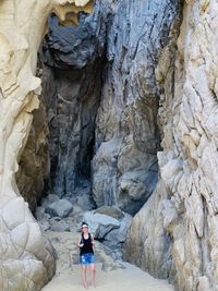 Full length of woman standing by rock formation