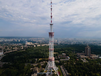 Aerial view of buildings in city against cloudy sky