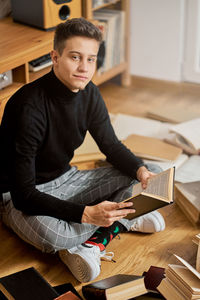 Man using mobile phone while sitting on table at home