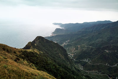 Scenic view of sea and mountains against sky