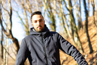 Portrait of young man standing in forest