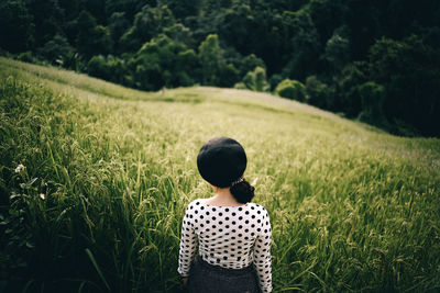 Rear view of woman standing on field