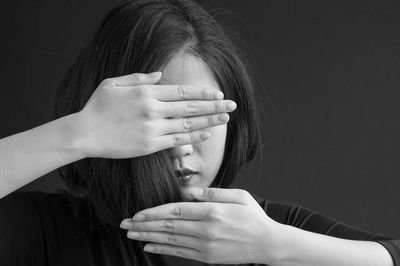 Close-up of woman against black background