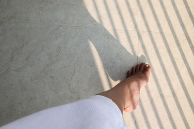 Low section of woman standing on tiled floor