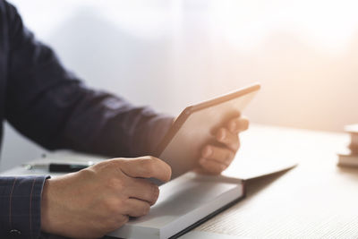 Close-up of man using mobile phone on table