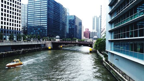 Bridge over river amidst buildings in city