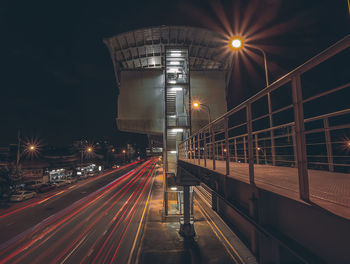 Light trails on road against sky at night