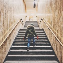 Rear view of boy walking on stairs