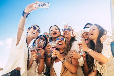 Cheerful women taking selfie while enjoying at party